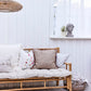 Novie Bamboo Pendant Lamp hanging above a cozy seating area in a stylish, white-walled room.