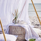 Olivia Tablecloth Ø140 cm with sand striped pattern on a table by the beach.