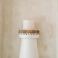 White natural pretty candle holder with raffia accent and candle.